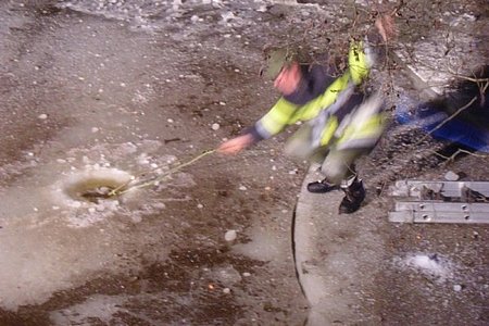 Eine Sprengladung wird unter der Eisschicht platziert.